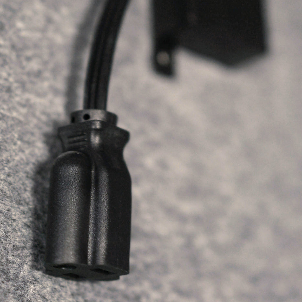 close-up of a black electrical connector cable on a textured surface